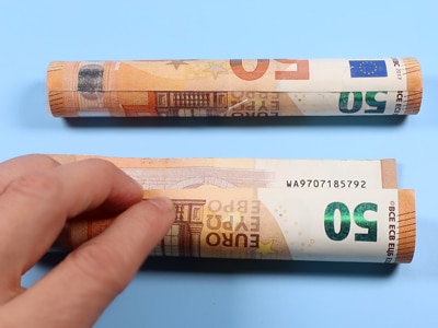 Kerze in einen Geldschein einrollen