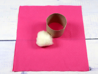 Watte und Papprolle auf Serviette positionieren